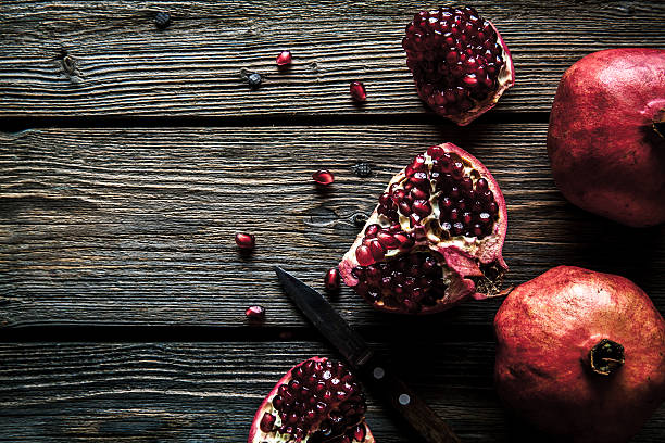 istock Fresh pomegranates on wooden background. 636004120