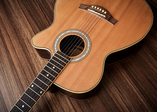 istock Acoustic guitar laid on wooden floor background. 636005192