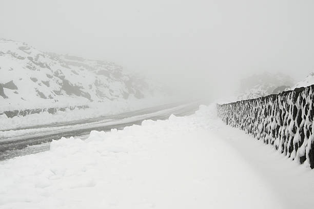istock Snowstorm in the mountain road 636009972
