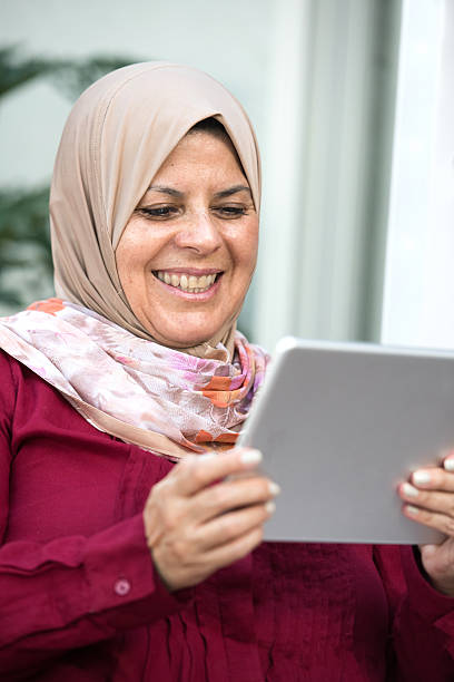 muçulmanos mulher usando um tablet eletrônico - cairo women middle east islam - fotografias e filmes do acervo