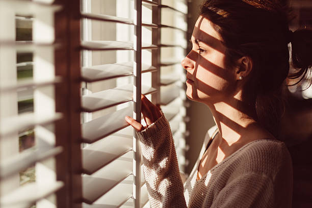 istock Sad woman looking through the window 636012200