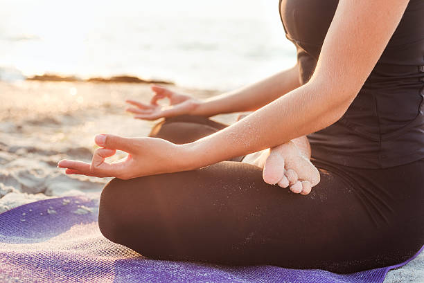 istock young caucasian female practicing yoga on beach 636013038