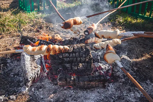 Bread on sticks over an outdoor campfire in the summer