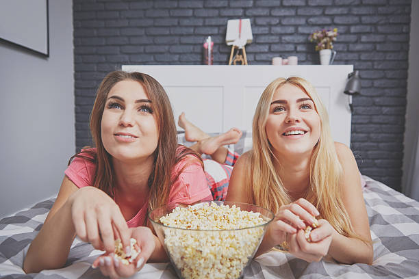 istock Friends watching interesting movie in bedroom 636018550
