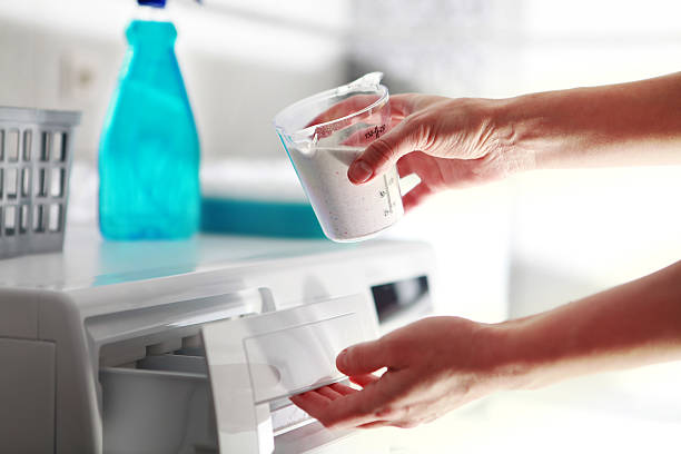 hands of woman that fills detergent in the washing machine