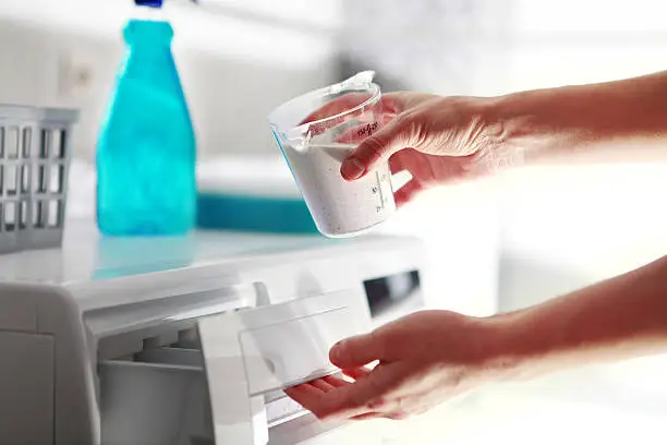 Photo of hands of woman that fills detergent