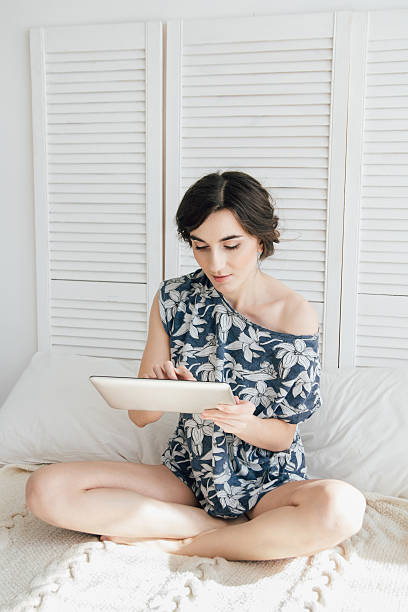 istock Girl looking at tablet in bed 636022040