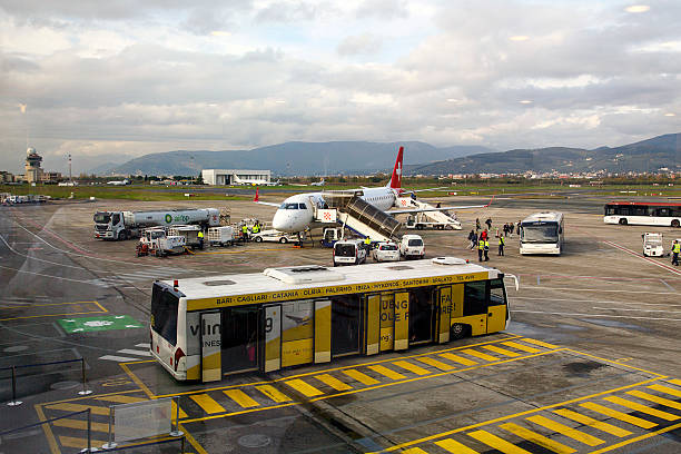 Florence airport - Italy Florence, Italy: November 20, 2016: A Swissair airbus is having luggage removed from the hold as passengers disembark from the flight at Florence Airport. Swissair AG/S.A. was for many years the national airline of Switzerland. It was formed from a merger between Balair and Ad Astra Aero, in 1931. florence italy airport stock pictures, royalty-free photos & images