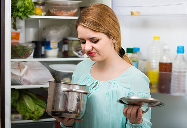 woman noticed foul smell of food from casserole Long-haired spanish woman noticed foul smell of food from casserole rotting stock pictures, royalty-free photos & images