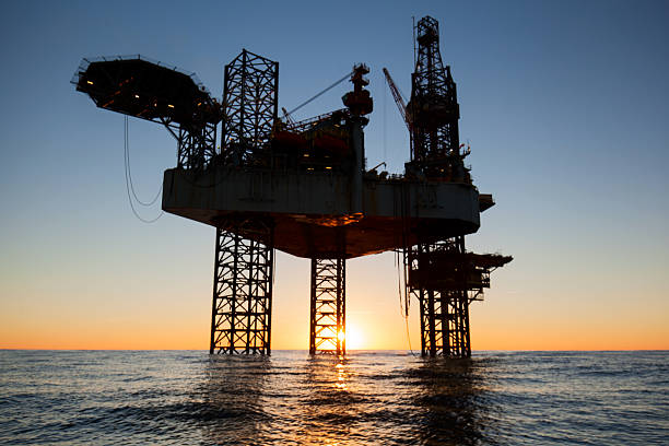 istock Silhouette of an offshore oil drilling rig 636033832