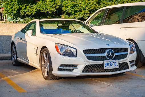 Toronto, Canada - July 20, 2015: A white colored Mercedes-Benz SL-Class grand touring roadster parked in a parking lot in Toronto, Ontario.