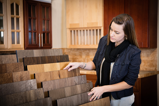 Woman shopping for  flooring in a home interiors store.
