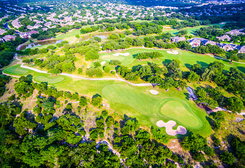 Summer landscape Texas Hill Country Gold Course with Green and Sand Pits surrounded By Trees and Countryside Suburban Homes outside of Austin , Texas in Round Rock. 