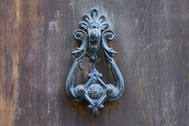 istock Old metal knocker on a wooden door 636037554