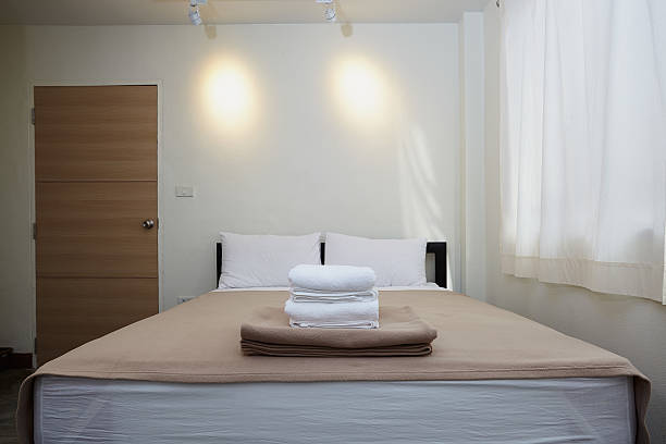 istock white king size bed, two pillows and towel in bedroom 636040540