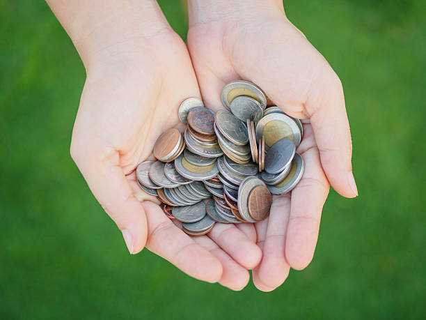 istock abstract money saving human hand is holding coins 636041142