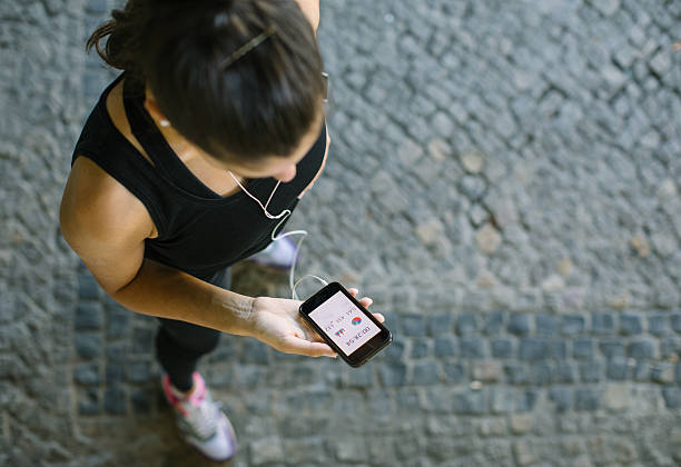 mujer monitoreando su progreso de entrenamiento en la aplicación de fitness - electro music fotografías e imágenes de stock