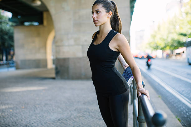 femme de fitness échauffement avant une course - railing beautiful human leg people photos et images de collection