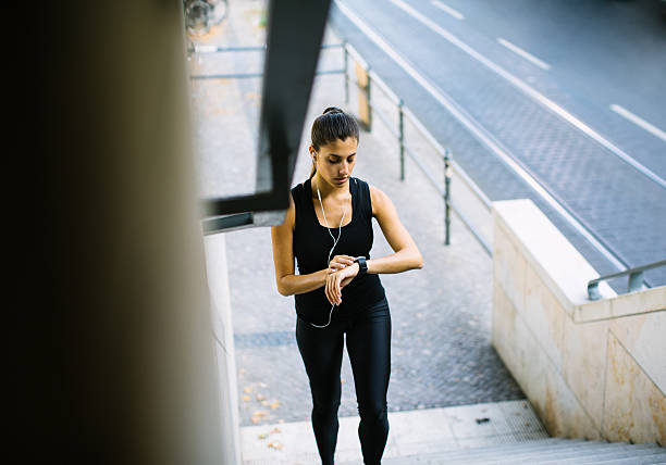 здоровая женщина на шагах проверки смарт-часы - jogging running taking pulse women стоковые фото и изображения