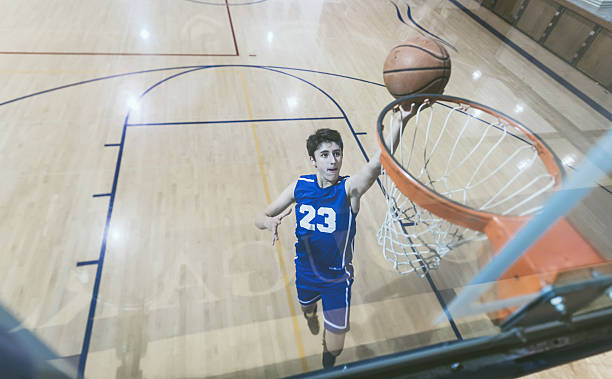 istock High school basketball player rising up for a layup 636044646