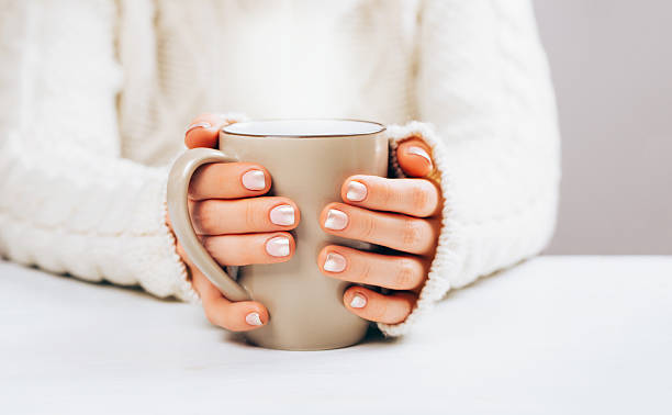 Woman with manicure and cup.