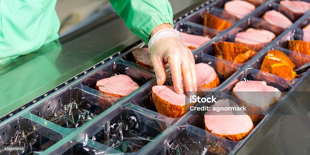 Raw meat production Several chunks of raw meat being processed packaged and shipped Meat Stock Photo
