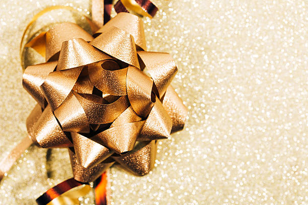 istock Golden ribbon bow with little sparkles in bokeh 636047190