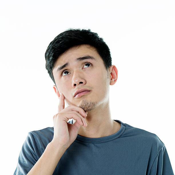 istock Thoughtful young asian man against white background 636048676