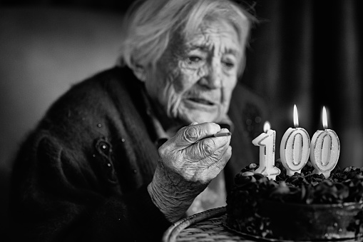 Grandmother at her birthday is lighting cigarette