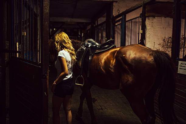 istock Girl and her horse in stable 636057638
