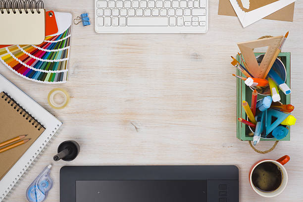 istock Graphic designer desk essentials top view with wooden texture background 636059306