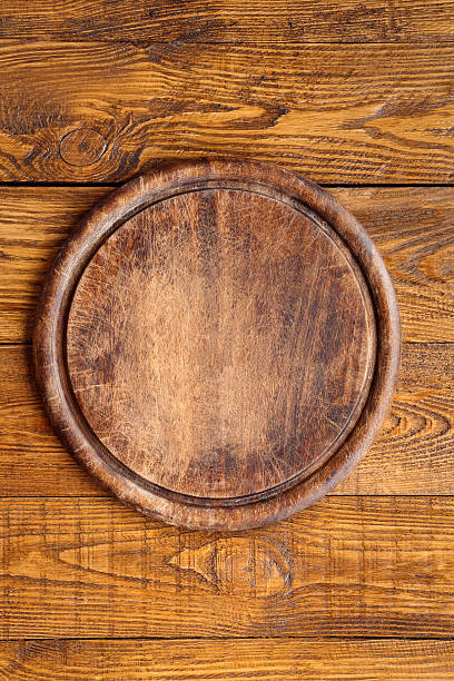 istock Wooden round board for pizza 636066280