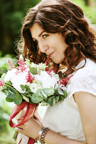 istock Young smiling bride with wedding flowers 636068422