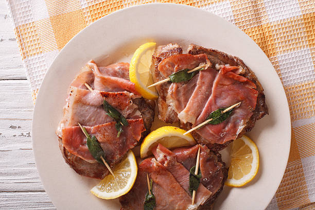 cuisine italienne: saltimbocca de bœuf au citron en gros plan. horizontal - saltimbocca veal prosciutto ham photos et images de collection