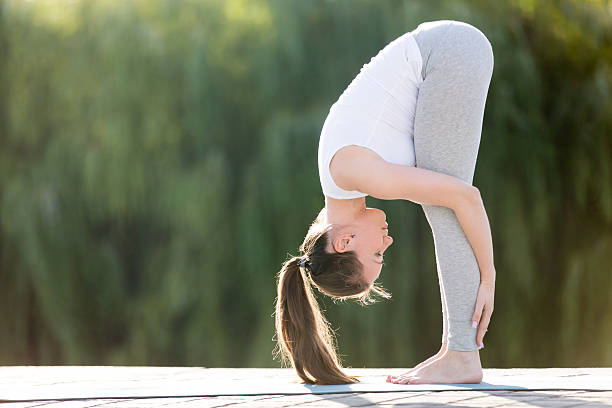 forward bend head to knees pose - forward fold imagens e fotografias de stock