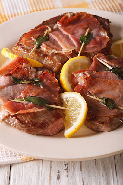 bœuf italien saltimbocca avec gros plan sur la sauge, le jambon et le citron. vertical - saltimbocca veal prosciutto ham photos et images de collection