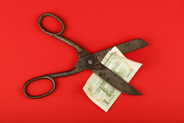 istock Scissors cut Chinese yuan over red background 636070748