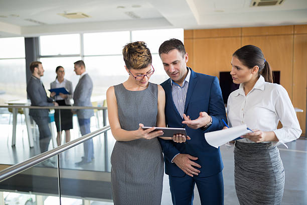 istock Three business people discussing business strategy using digital tablet 636071326