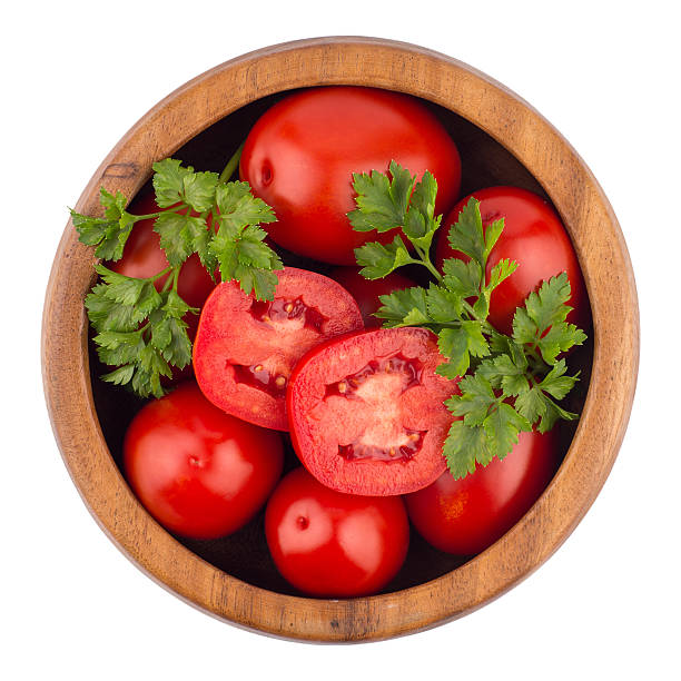istock fresh tomatoes in wood bowl on white background. 636071566