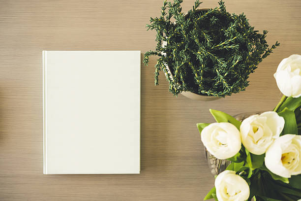 istock Mock up Book cover on table with White rose Flower 636071578