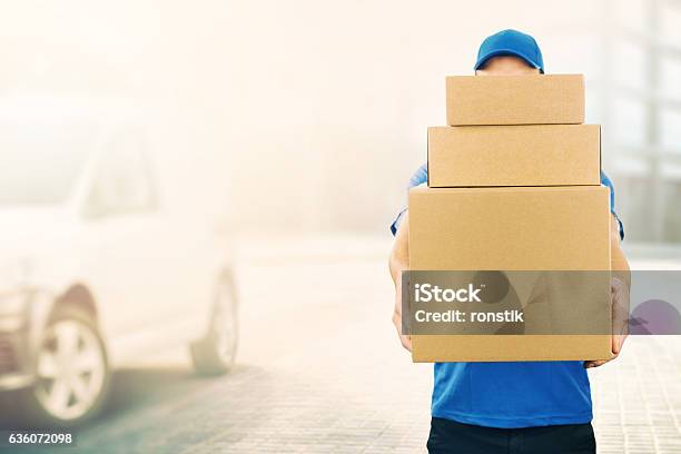 Delivery Man Holding Pile Of Cardboard Boxes In Front Stock Photo - Download Image Now