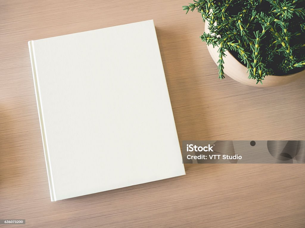 Mock up white Book cover on table with Green Plant Mock up white Book cover on wooden table with Green Plant Book Stock Photo