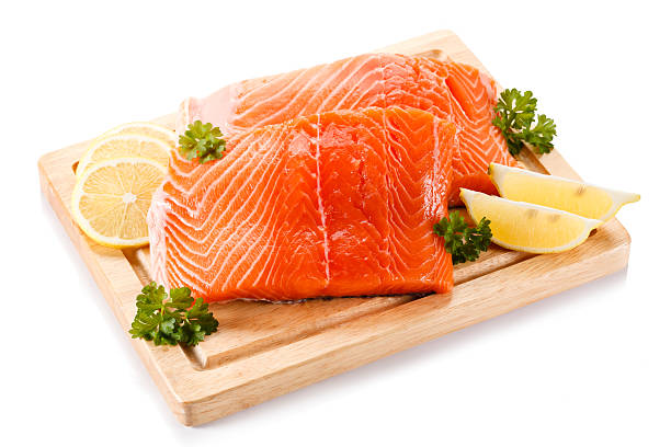 istock Fresh raw salmon fillet on cutting board on white background 636074124