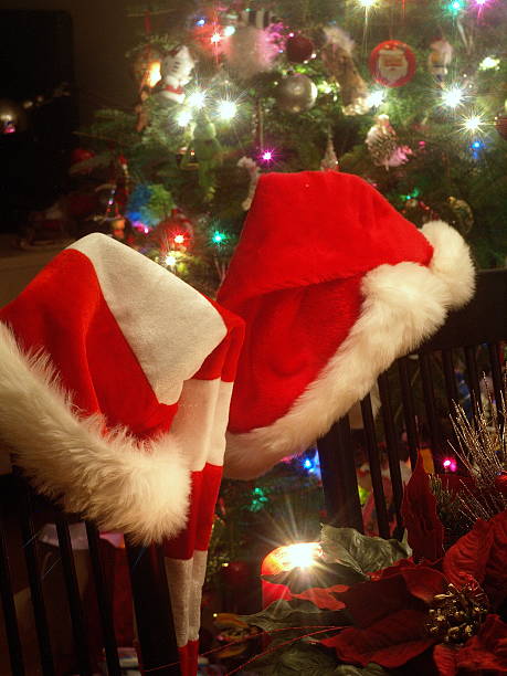 sombrero de santa a la luz de las velas con fondo de árbol de navidad - guyver fotografías e imágenes de stock