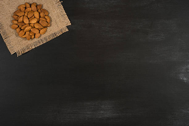 istock Almonds on sackcloth and black chalkboard. 636074604