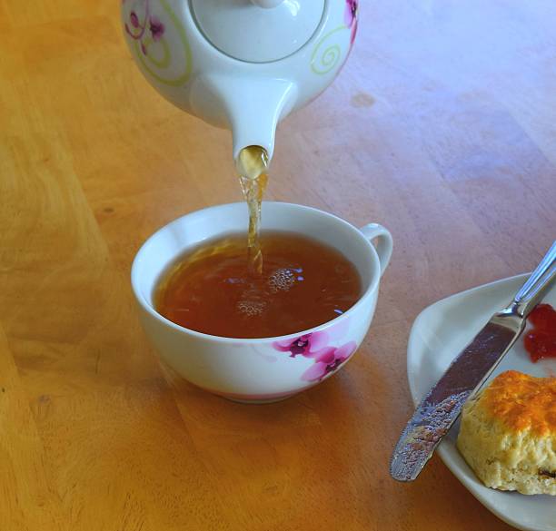 istock pouring English tea from teapot hot drink 636078720