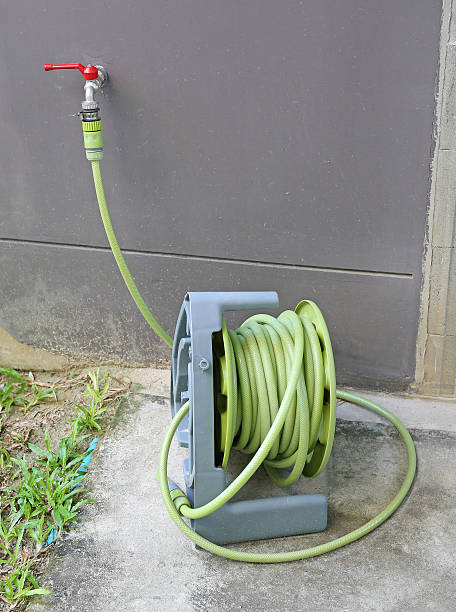 istock water tap with green rubber tube roll up 636080934