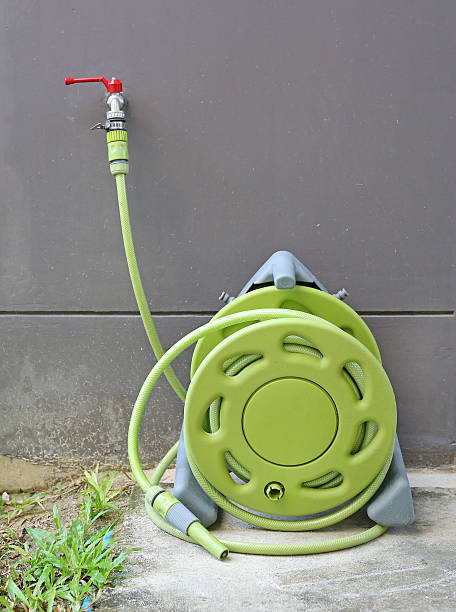 istock water tap with green rubber tube roll up 636080992