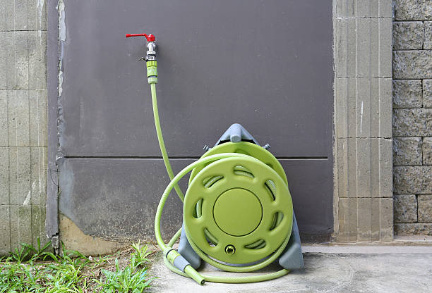 istock water tap with green rubber tube roll up 636081064