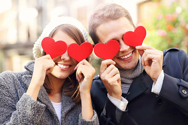 istock Happy couple covering eyes with hearts 636081126
